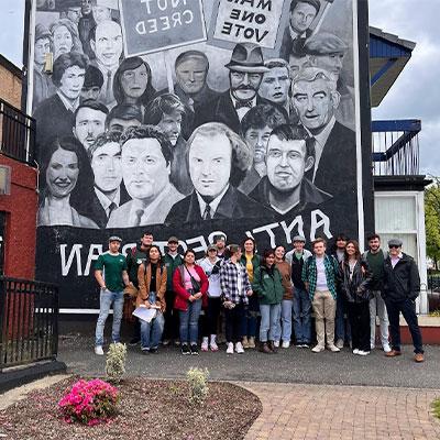 students in front of political art